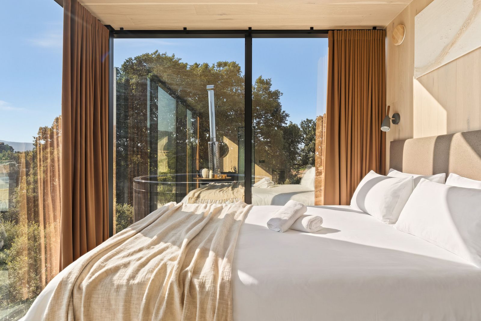 Dormitorio de una Casa Espejo de Cork Valley con el jacuzzi nórdico privado visto a través del cristal